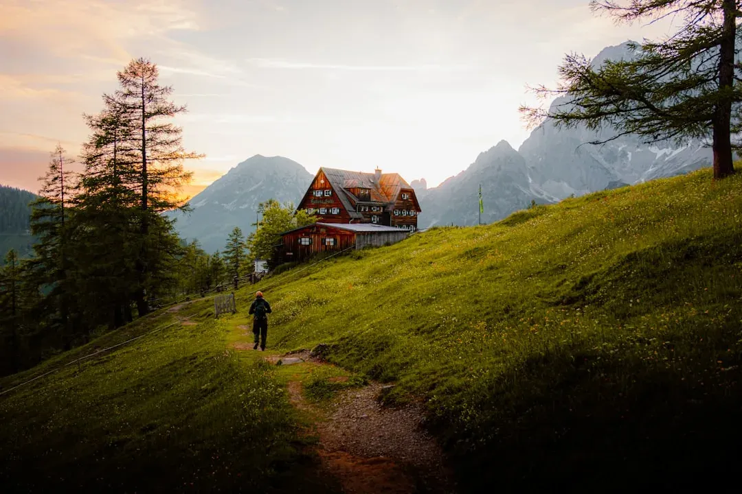hiker approaching mountain hut with backpack